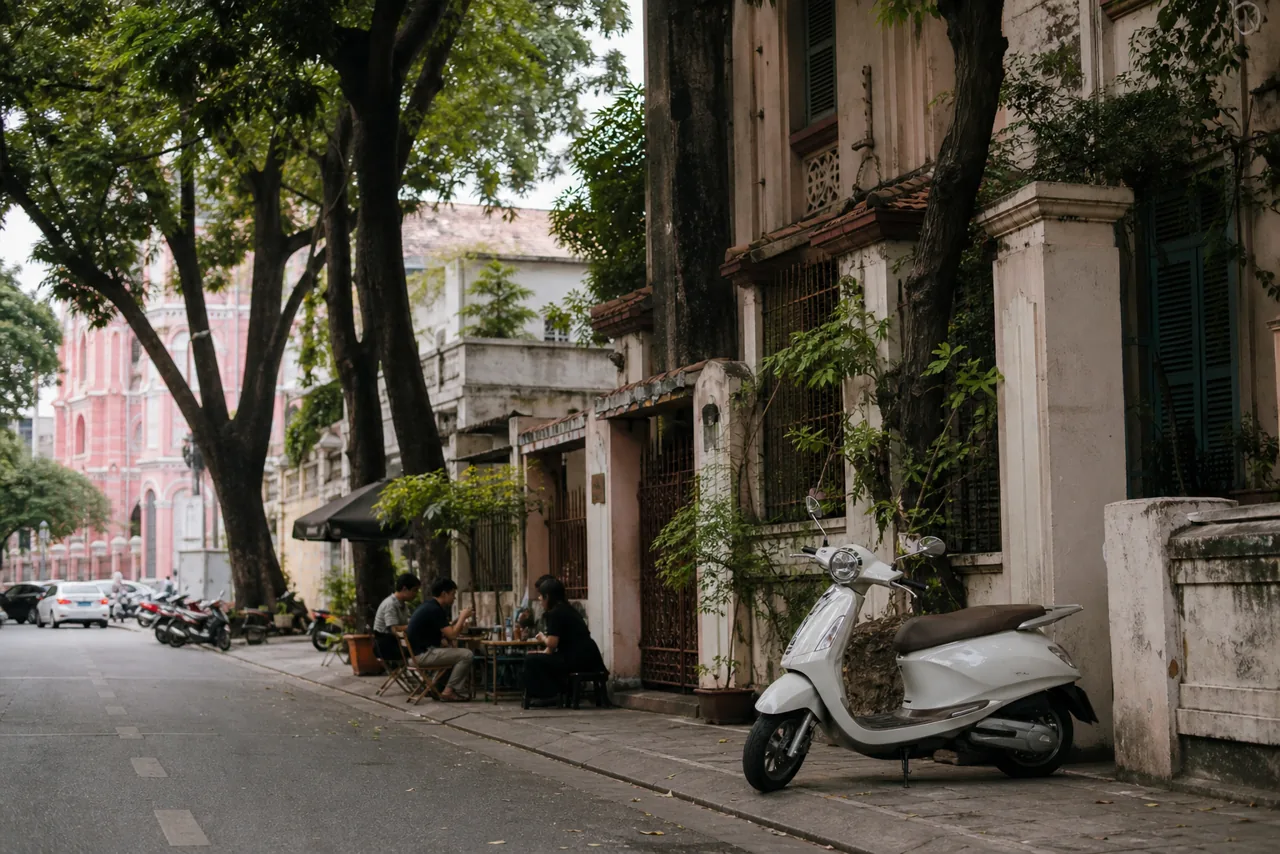 Parked scooter on a tree-lined District 3 street with heritage architecture and cafés