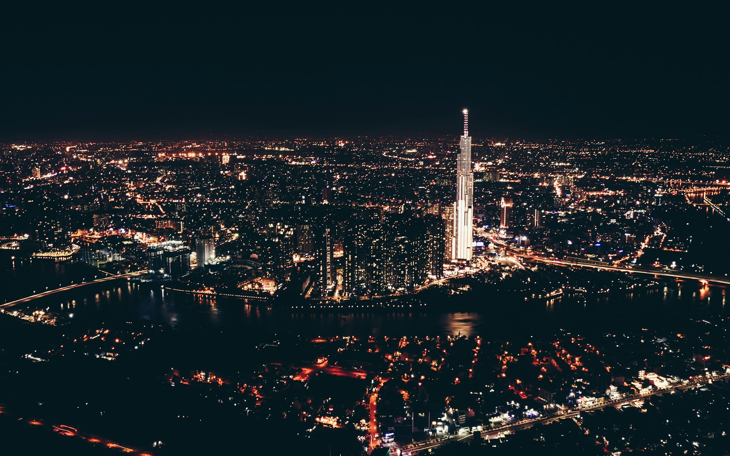 Aerial night view of Ho Chi Minh City, the Saigon River and the illuminated skyline